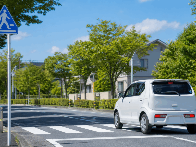 道の日に安全運転をする車と道路標識
