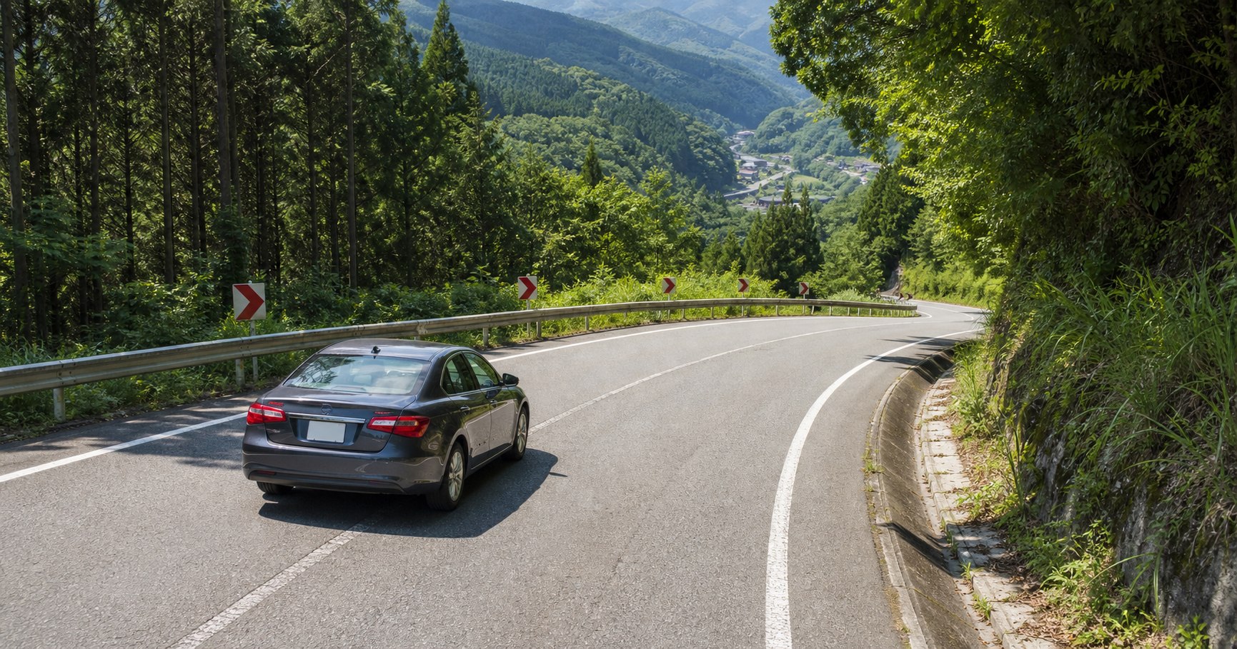 山道の下りカーブ手前で減速する車