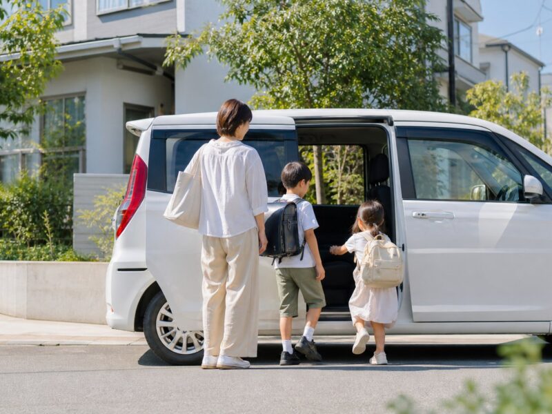 夏休み明けに子どもを車で送迎する家族