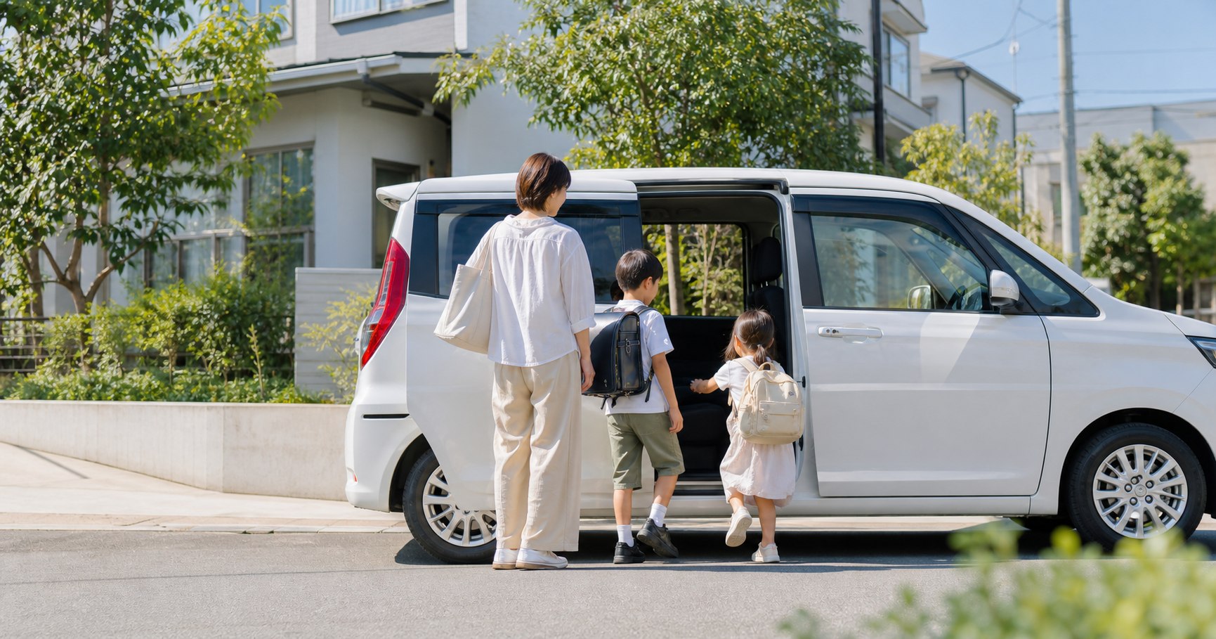 夏休み明けに子どもを車で送迎する家族
